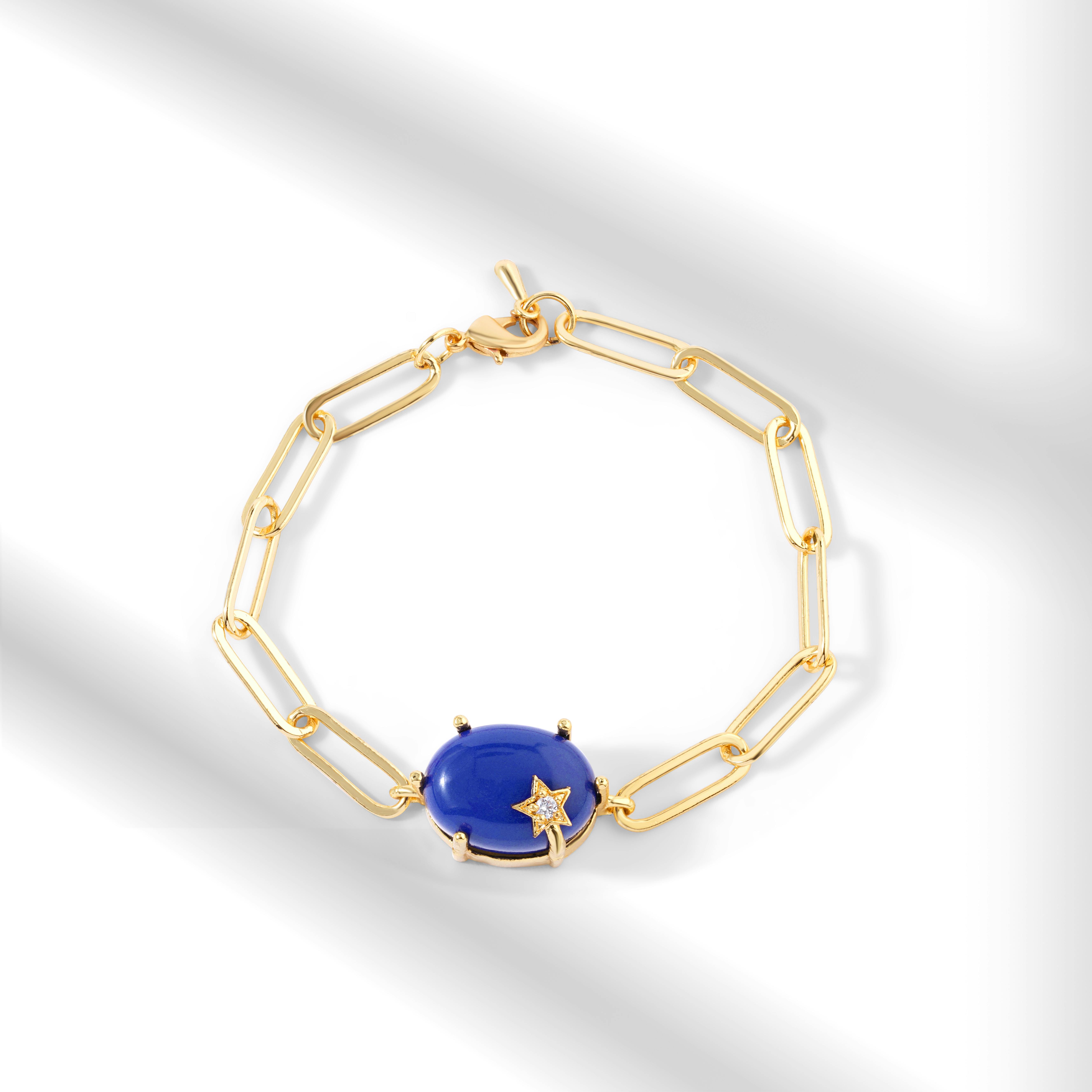 Luxury gold bracelet featuring a vibrant blue gemstone and star embellishment.