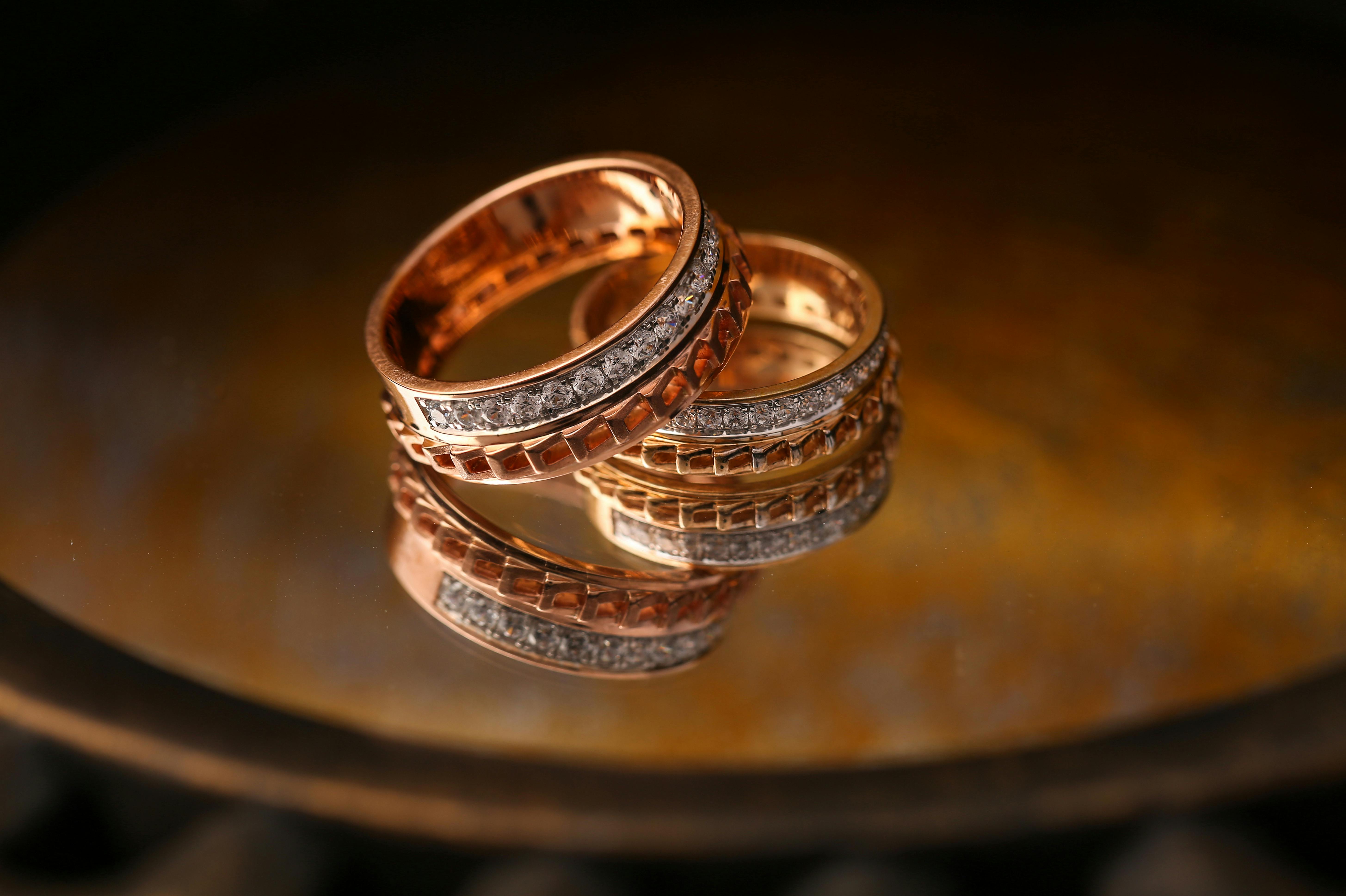 pexels-photo-5737277-5737277 Close-up of luxury gold and diamond wedding rings reflecting light beautifully.